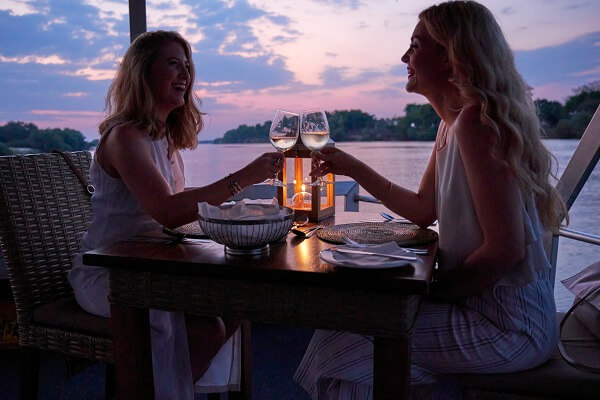 two ladies enjoying wine on a dinner cruise on Zambezi  river 