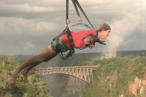 man-doing-flying-fox-with-bridge-in-the-background-victoria-falls