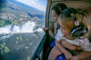 Mother and child in helicopter flying over victoria falls
