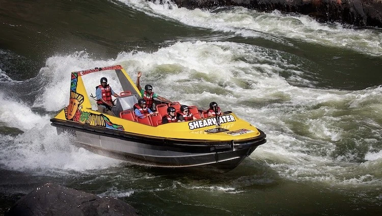 Tourist on jet boat being driven under the Victoria Falls moments before hitting the spray!