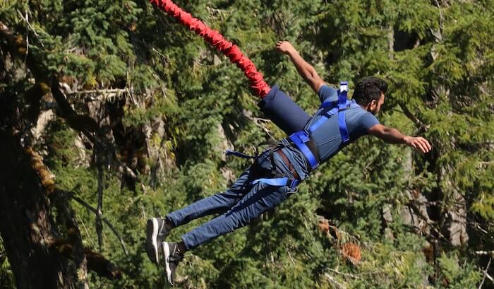Man just jumping of gorge attached to bungee cord